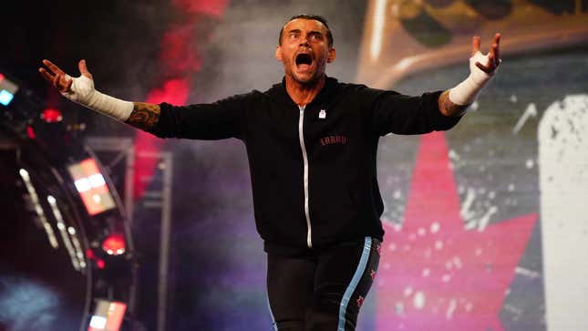 CM Punk makes his way down the entrance ramp with his arms stretched out screaming in excitement for returning to wrestling after seven years. 