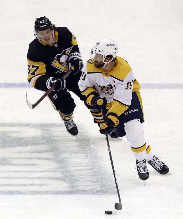 Apr 10, 2022; Pittsburgh, Pennsylvania, USA;  Nashville Predators defenseman Roman Josi (59) handles the puck against Pittsburgh Penguins right wing Rickard Rakell (67) during the second period at PPG Paints Arena.