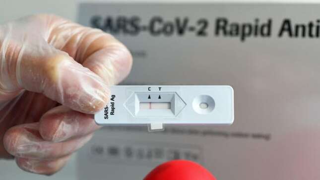 A doctor shows a negative rapid antigen test at the Corona test center in a specially created room next to the ‘Loewen’ pharmacy in Hagen, western Germany on March 10, 2021.
