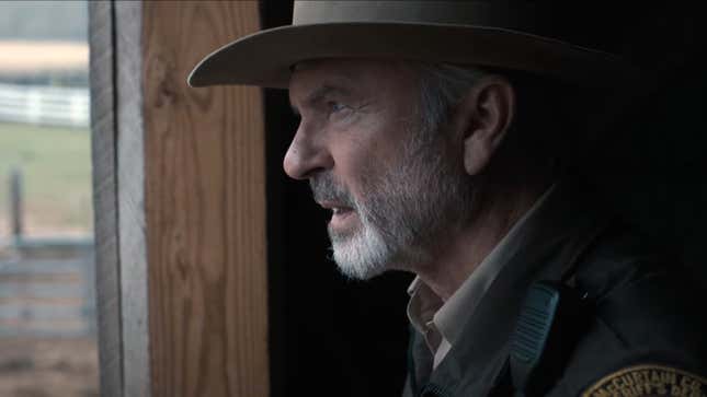 A bearded, hat-and-uniform-clad Sam Neill looks out a window in alien drama Invasion.