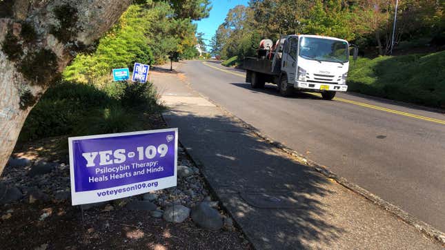 A truck drives past a sign supporting a ballot measure in Oregon to legalize the controlled, therapeutic use of psilocybin mushrooms. 