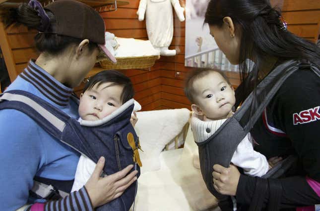 Two mothers carry babies in South Korea