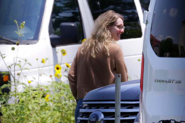 Disgraced Theranos CEO Elizabeth Holmes, right, is escorted by prison officials into a federal women’s prison camp.