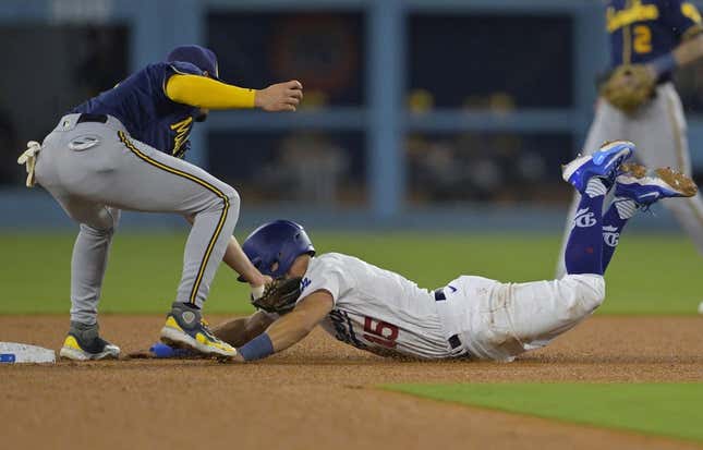 Aug 17, 2023; Los Angeles, California, USA;  Los Angeles Dodgers catcher Austin Barnes (15) beats the throw to Milwaukee Brewers shortstop Willy Adames (27) for a stolen base in the third inning at Dodger Stadium.