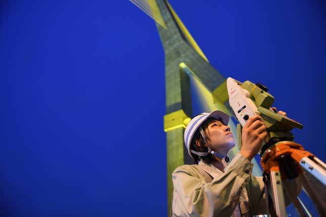 Employee Ayuna Kitaura alongside the company’s patented surveying tool — part camera, part computer, all designed to save money and lives.