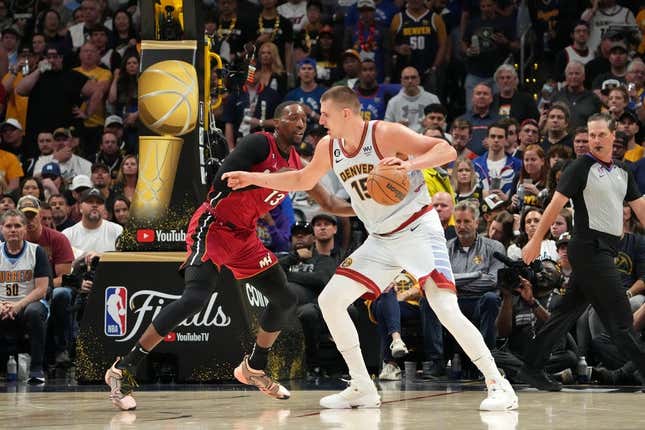 Jun 12, 2023; Denver, Colorado, USA; Denver Nuggets center Nikola Jokic (15) dribbles the ball against Miami Heat center Bam Adebayo (13) during the third quarter in game five of the 2023 NBA Finals at Ball Arena.