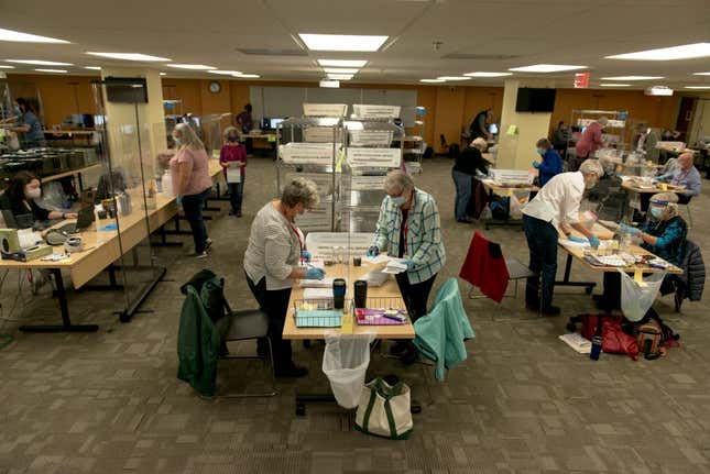 Election officials and volunteers process absentee ballots at Ramsey County’s absentee ballot count center on November 2, 2020, in St Paul, Minnesota. 