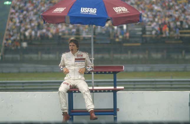 Arrows Megatron driver Eddie Cheever of the USA sits under an umbrella before the 1988 Brazilian Grand Prix at the Rio circuit in Brazil. Cheever finished in eighth place.