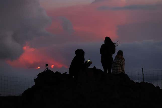 Clouds glow orange from the glow of lava that is flowing from the Mauna Loa volcano on December 03, 2022 near Hilo, Hawaii. 