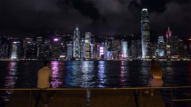 A photo of the skyline in Hong Kong illuminated at night. 