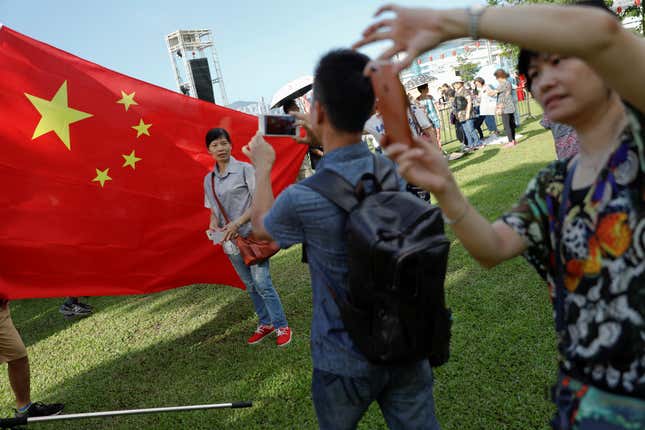 People take pictures of themselves as pro-China supporters gather in a Hong Kong park.