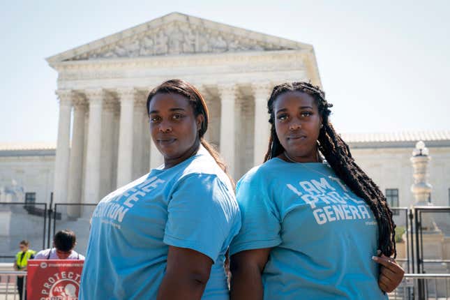 K’Vone Cropp, 26, left, and her twin sister Kayla Cropp, 26, of Richmond, Va., pose for a portrait while protesting with the group Students For Life, outside the Supreme Court about abortion, Wednesday, June 15, 2022, in Washington. “We aren’t big talkers,” said Kayla. “We are just here supporting the cause and abolishing abortion.”