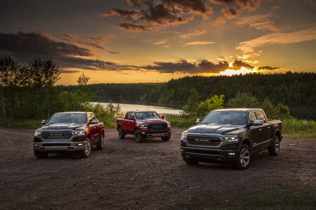 Three Ram 1500 diesels parked on dirt at sunset.