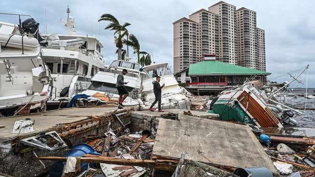 Residents inspect damage to a marina as boats are partially submerged in the aftermath of Hurricane Ian in Fort Myers, Florida, on September 29, 2022.