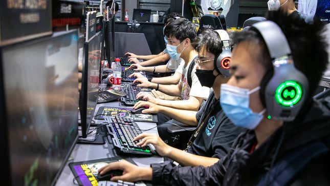 Young Chinese people playing games on a PC at an event.