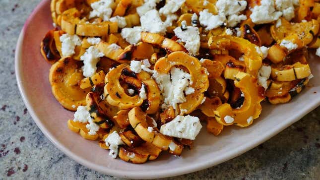 Roasted delicata squash with goat cheese on platter