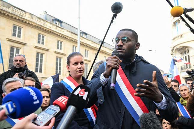 France Insoumise (LFI) party parliament member Carlos Martens Bilongo (C) delivers a speech during a demonstration organized by France Insoumise (LFI) to denounce racist remarks made by a far-right member of parliament directed at him during a National Assembly session one day prior, outside the National Assembly in Paris, on November 4, 2022. - A French parliament session was thrown into turmoil on November 3, 2022, after a far-right MP was accused of yelling “back to Africa” to Carlos Martens Bilongo of the leftist France Unbowed party (LFI), posing a question on migrant arrivals to the government.