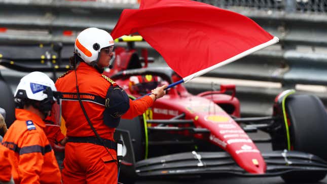 A photo of a marshal waving a red flag during an F1 race. 
