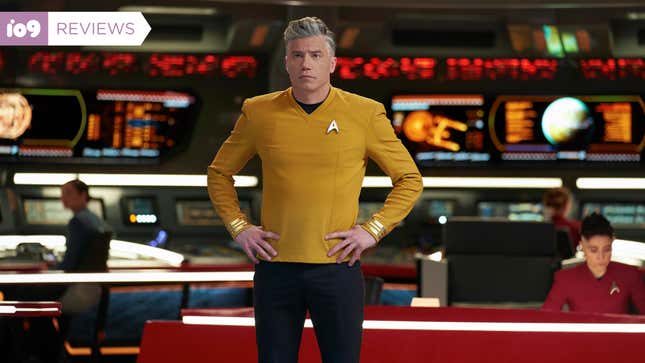 Anson Mount's Captain Christopher Pike stands hands on hips at the front of the USS Enterprise's bridge, as officers work at stations in the background behind him.