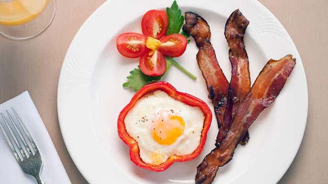 bacon on breakfast plate with pepper and egg