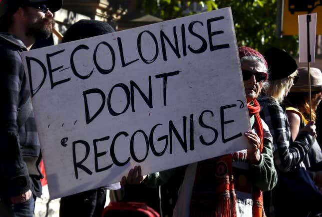 Aboriginal protesters hold banners and chant slogans during a protest outside a government office building in Sydney, Australia