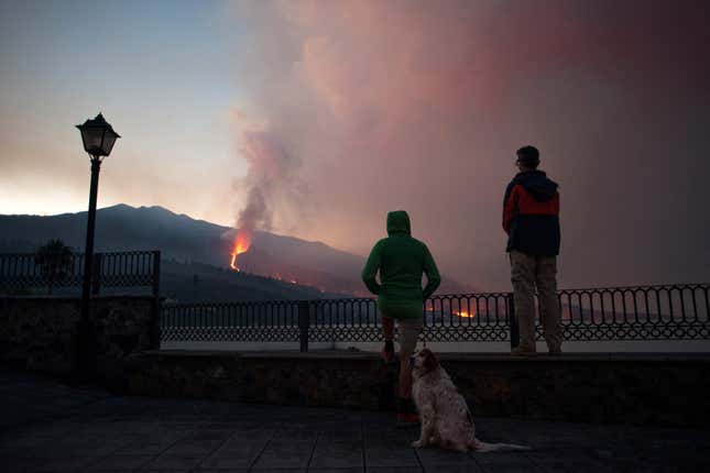 People observe as the Cumbre Vieja volcano spews lava, ash and smoke, in Los Llanos de Aridane, in the Canary Island of La Palma on October 10, 2021.
