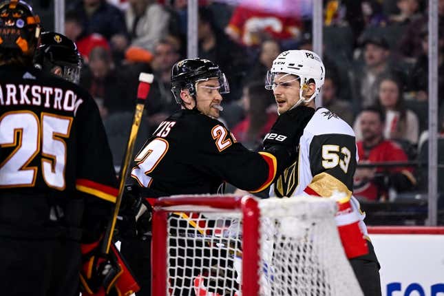 Mar 23, 2023; Calgary, Alberta, CAN; Calgary Flames center Trevor Lewis (22) grabs Vegas Golden Knights center Teddy Blueger (53) after a whistle during the second period at Scotiabank Saddledome.