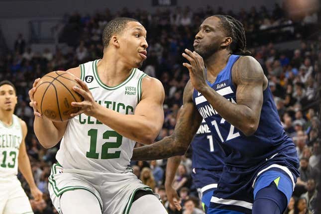 Mar 15, 2023; Minneapolis, Minnesota, USA;  Boston Celtics forward Grant Williams (12) protects the ball from Minnesota Timberwolves forward Taurean Prince (12) in the first quarter at Target Center.