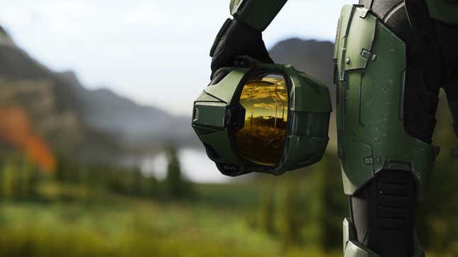Master Chief holds a helmet in key art for Halo Infinite.