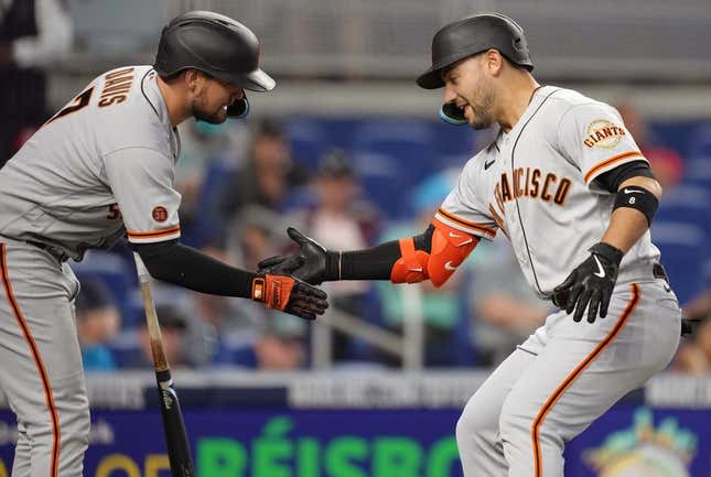 Apr 19, 2023; Miami, Florida, USA;  San Francisco Giants right fielder Michael Conforto (right) celebrates a two-run home run with first baseman J.D. Davis (7) in the se inning against the Miami Marlins at loanDepot Park.