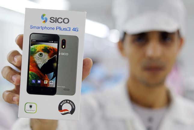 A factory worker holds up a package of Sico mobile phone in Assuit, Egypt September 30, 2018. Picture taken September 30, 2018.