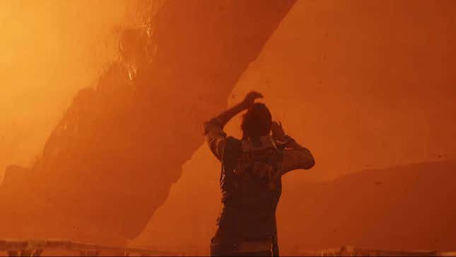 Un hombre camina a través de una tormenta de polvo naranja en un extraño planeta alienígena. 