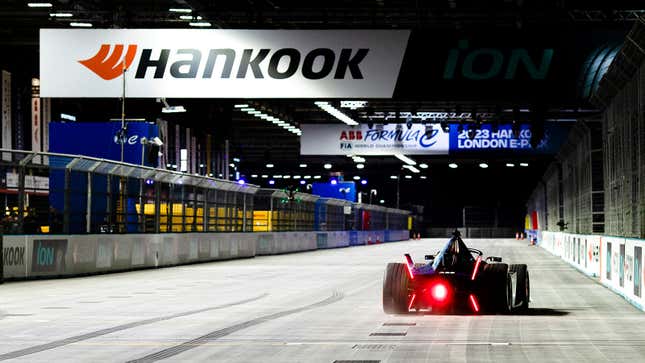 A photo of a Formula E car racing indoors. 