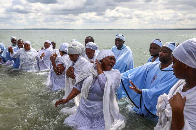 A woman reacts as senior members of the Apostles Of Muchinjikwa Christian church baptize members during a mass baptism (Jorodhani) on the beachfront on Southend-on-Sea, Britain.