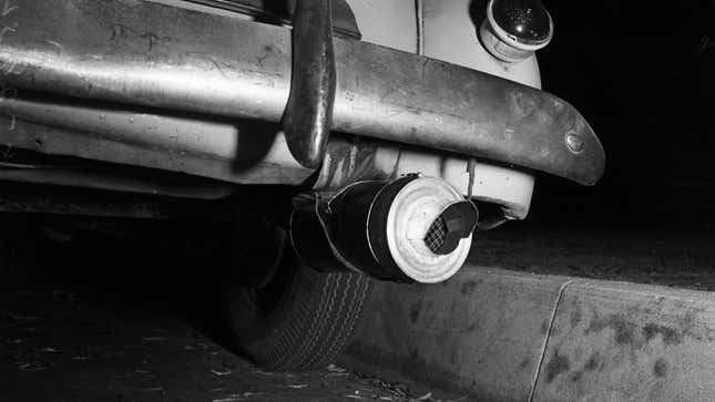 A black and white photo of a tailpipe on a vintage car. 