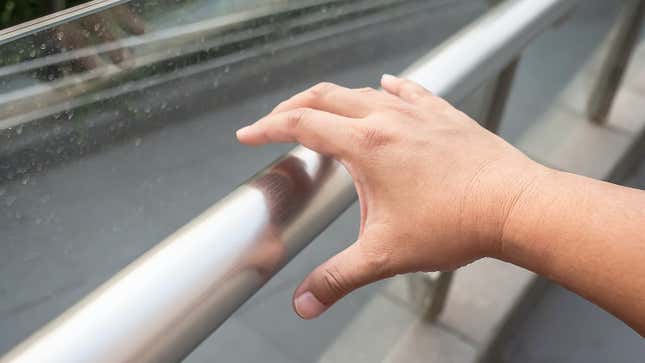 hand about to grasp a public handrail