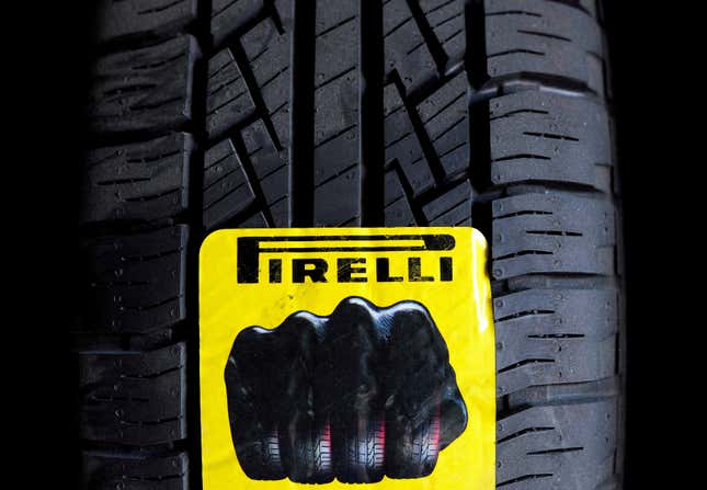 A closeup view of the tread of a Pirelli tire, with a yellow sticker of the logo stuck to the rubber.