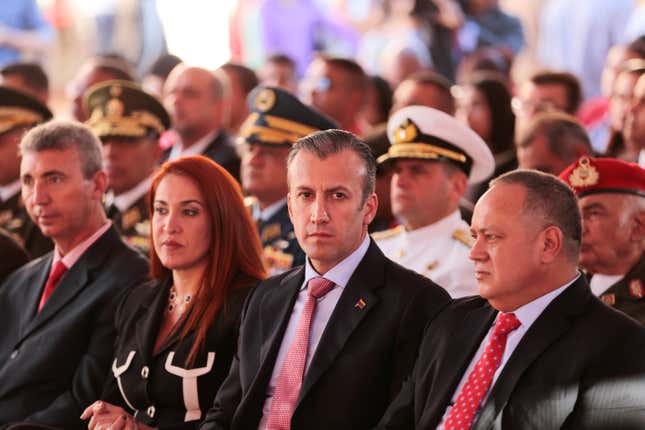 Tarek El Aissami is seated in an audience of people.