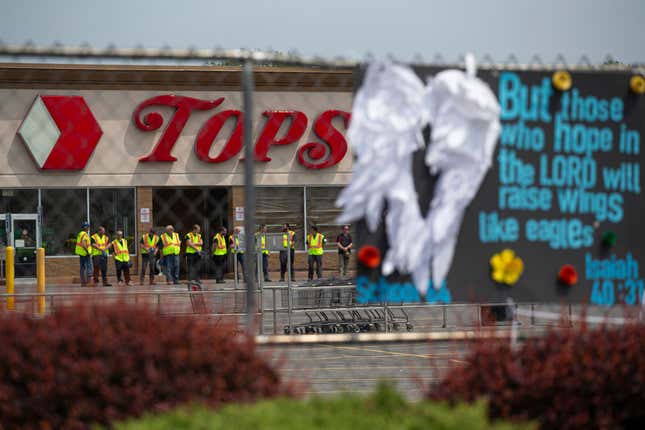 Investigators stand outside during a moment of silence for the victims of the Buffalo supermarket shooting outside the Tops Friendly Market on Saturday, May 21, 2022, in Buffalo, N.Y. Tops was encouraging people to join its stores in a moment of silence to honor the shooting victims Saturday at 2:30 p.m., the approximate time of the attack a week earlier. Buffalo Mayor Byron Brown also called for 123 seconds of silence from 2:28 p.m. to 2:31 p.m., followed by the ringing of church bells 13 times throughout the city to honor the 10 people killed and three wounded.