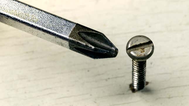 A Phillips head screwdriver near a screw it won't fit into