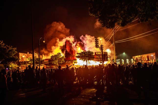 Protesters gather around a liquor store in flames near the Third Police Precinct on May 28, 2020 in Minneapolis, Minnesota, during a protest over the death of George Floyd,