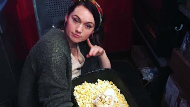 Writer kneeling by trash can full of popcorn