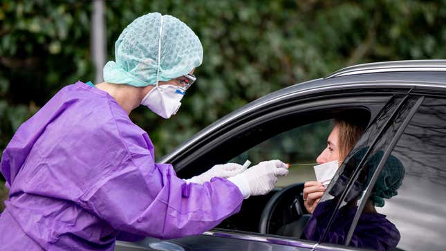 A doctor takes a sample for a coronavirus test on a fictional patient in her car at a drive-thru testing center on March 9, 2020 in Gross-Gerau, Germany in order to demonstrate for the media.