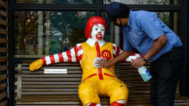 A worker cleans Ronald McDonald for the reopening of the outlet after it was shut down as a precaution against COVID-19.