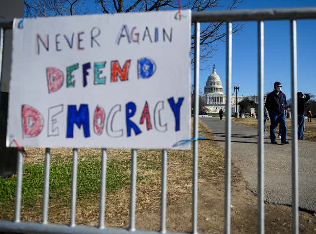 People pass signs of support near the US Capital in Washington, DC on January 10, 2021. - Donald Trump faced fresh calls Sunday from some members of his own party to resign over the violent incursion into the US Capitol, as the threat builds for a historic second impeachment effort in his final 10 days in the White House. 