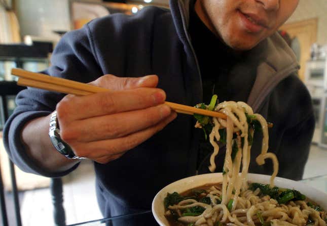 In this Nov. 20, 2003 file picture, a man uses chopsticks to eat noodles at a restaurant in Beijing, China.