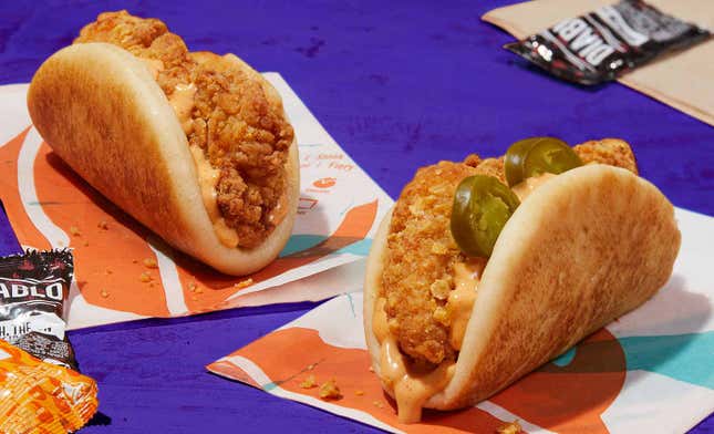 Product shot of the regular and spicy Crispy Chicken Sandwich Taco on a purple table