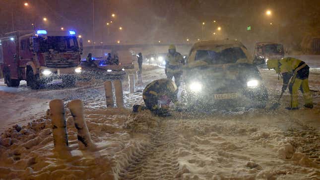 Firefighters help vehicles stuck in the M30 ring road in Madrid due to a heavy snowstorm on January 8, 2021. 