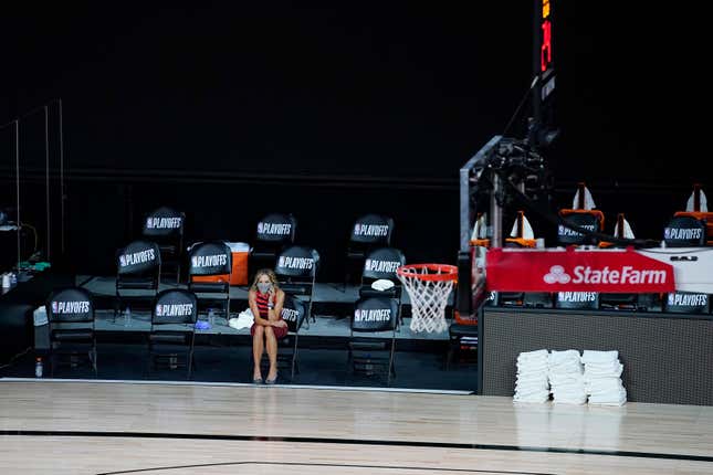 A reporter sits courtside in an empty arena during August’s NBA strike.
