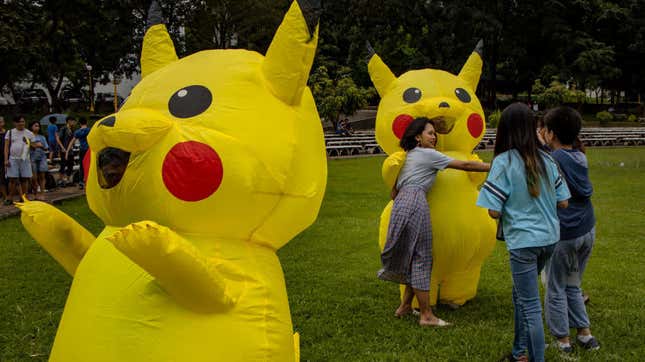 Children hug characters dressed as Pikachu